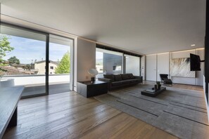Uma sala de estar moderna com um sofá, mesa de centro e uma grande janela.