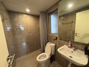 Ein Badezimmer mit Toilette, Waschbecken und Spiegel.