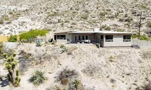A modern two-story house with a flat roof, large windows, and a covered patio area. - Natural Modern • 180deg Views • Hot/Cool Tub • Near Pappy and Harriet's (Yucca Valley)