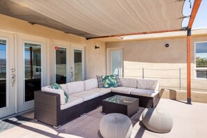 A covered outdoor seating area with a sectional sofa, two side tables, and a pergola. - Natural Modern • 180deg Views • Hot/Cool Tub • Near Pappy and Harriet's (Yucca Valley)