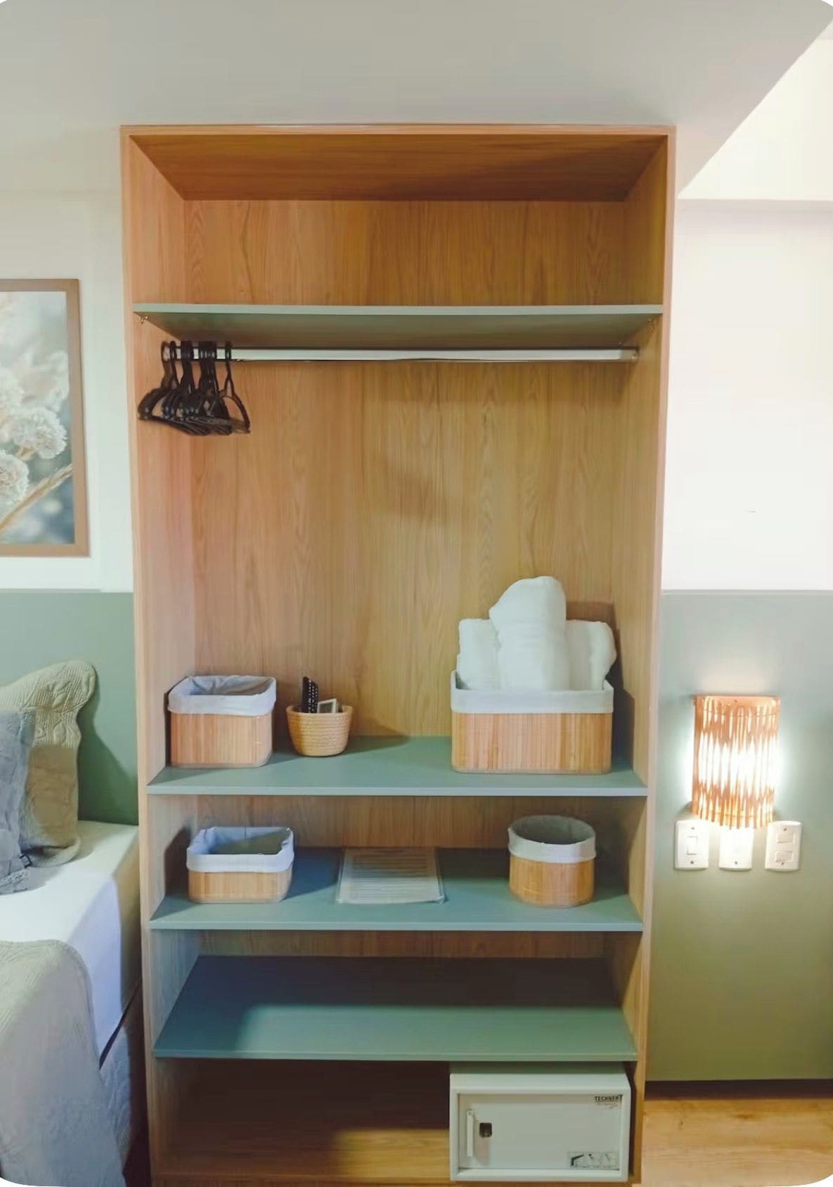 A wooden wardrobe with multiple shelves, a hanging rack, and a small cabinet.