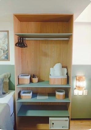 A wooden wardrobe with multiple shelves, a hanging rack, and a small cabinet.