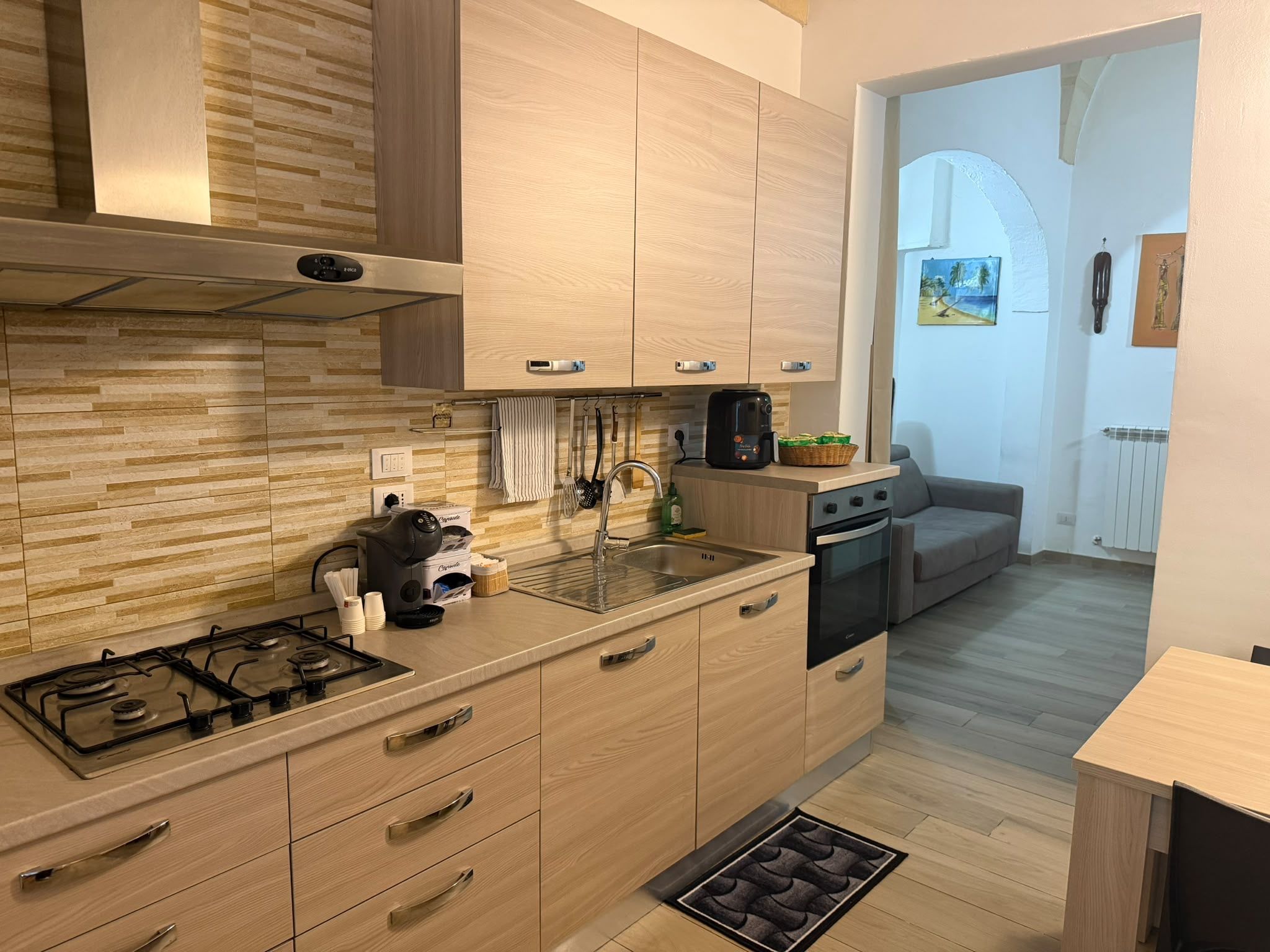 Une cuisine moderne avec des meubles en bois, une cuisinière à gaz et un four encastré.