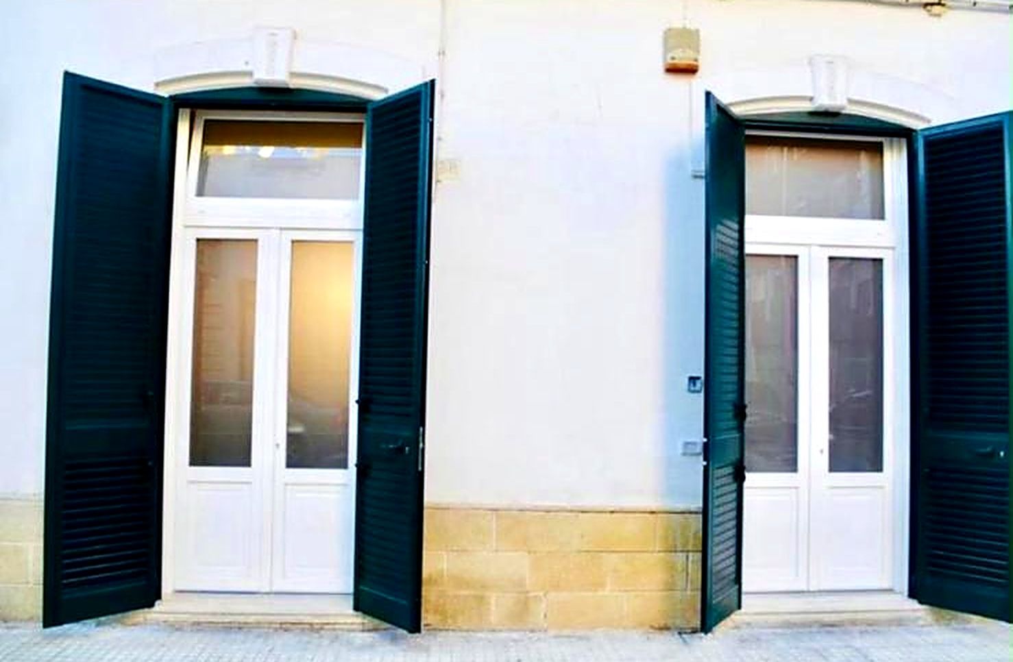 A building with two doors, each with a window above.