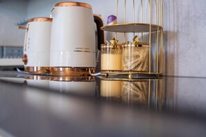 Eine Küche mit modernen Geräten, darunter eine Kaffeemaschine und ein Glasbehälter mit Deckel.