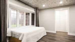 A bedroom with a large window, a bed, and a door. - Brand New - Private Renovated Estate - Secluded! (Brampton)