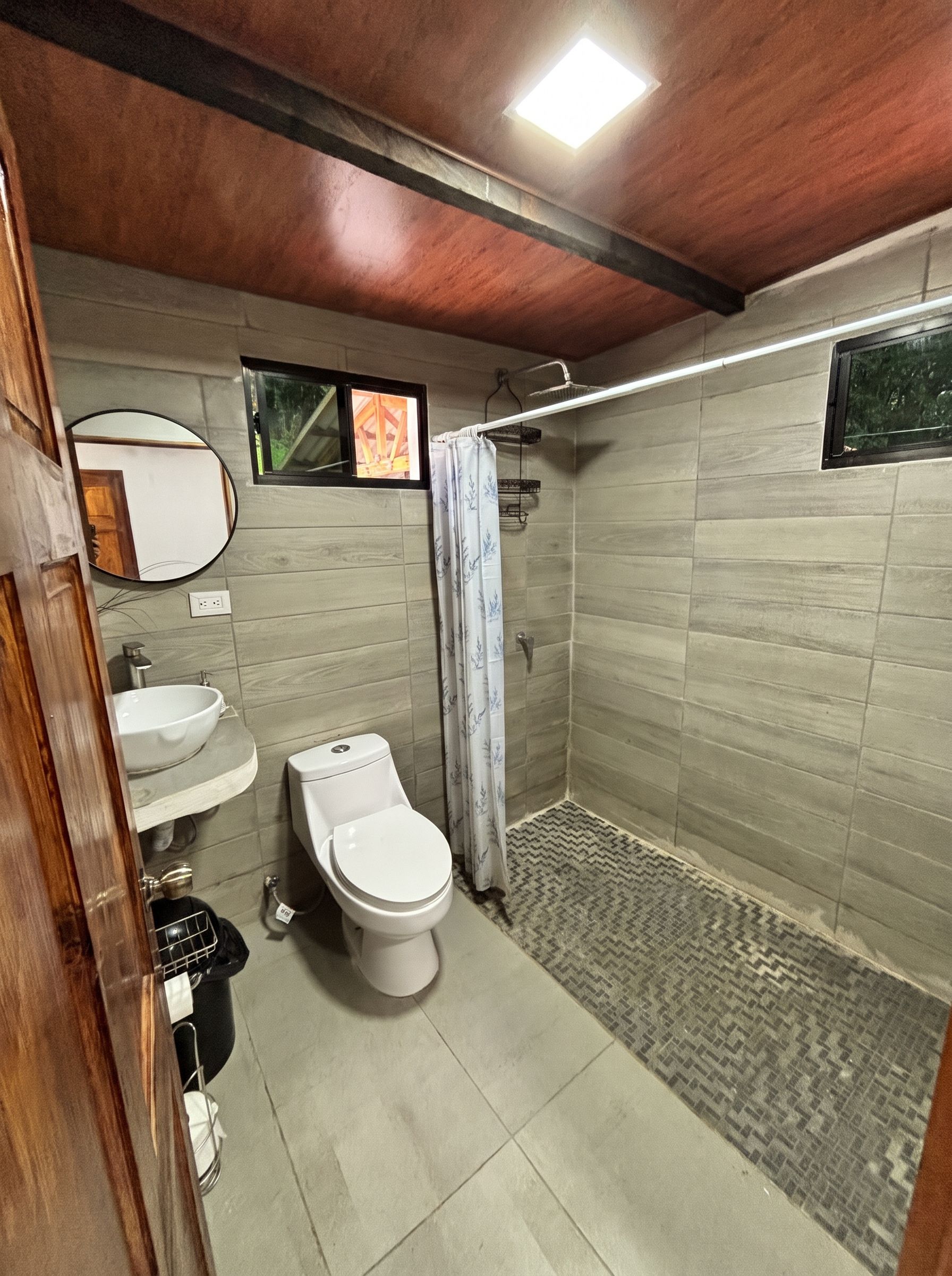A bathroom with a toilet, sink, and shower area.