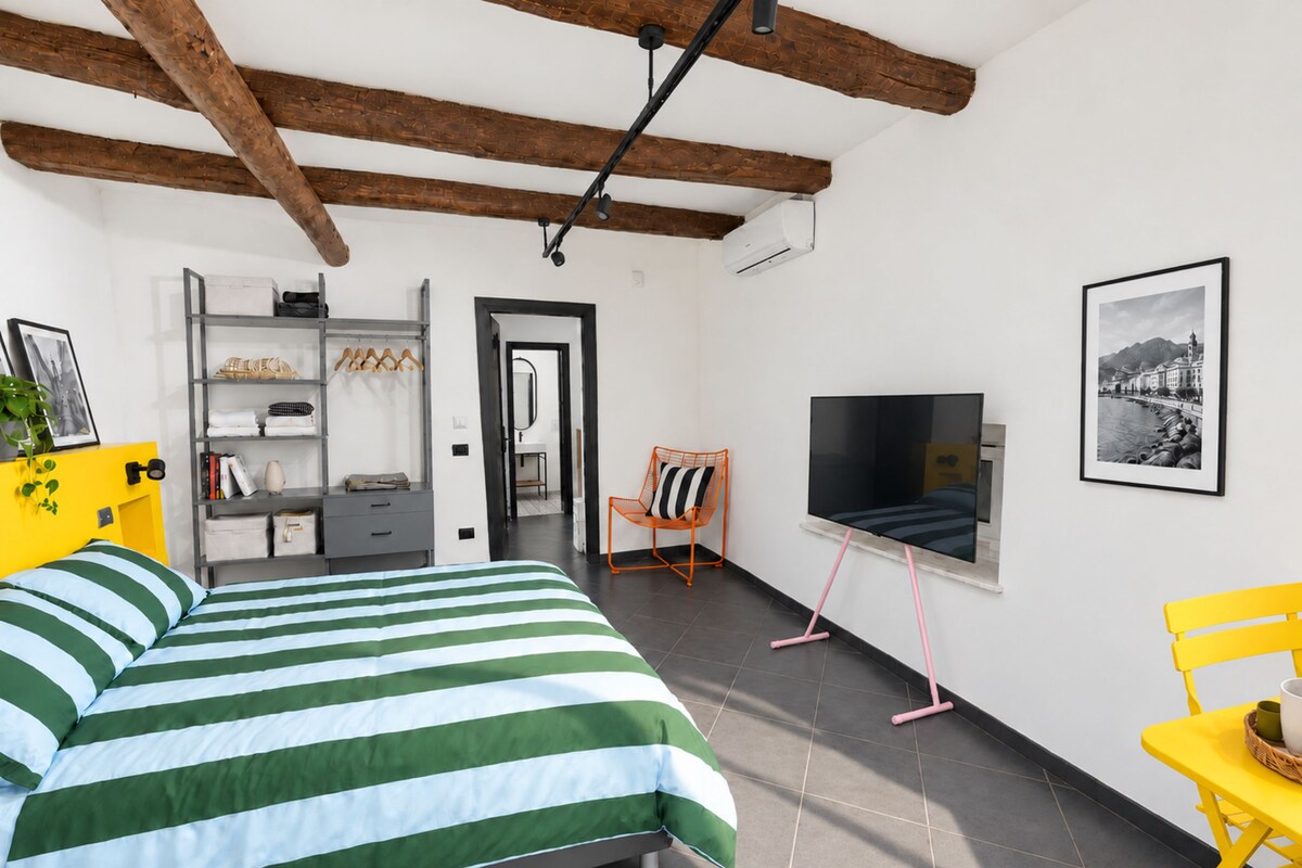 Una camera da letto con un letto, una TV e una sedia.