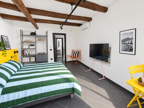 Una camera da letto con un letto, una TV e una sedia.