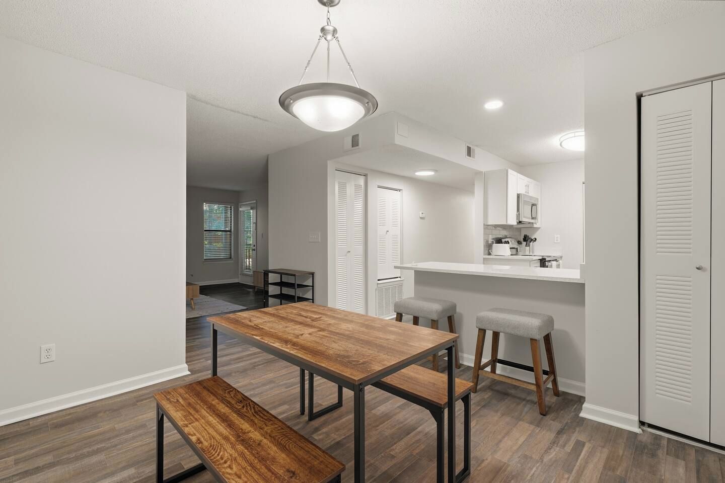 A modern kitchen with a white countertop, a microwave, and a sink.