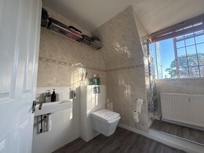A bathroom with a toilet, sink, and towel rack. - Lovely-bedroom house in London perfect for your city escape (London)
