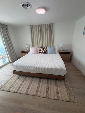 A modern bedroom with a large bed, two bedside tables, a ceiling light, and a view through a window. - Relax, Swim & Explore! Cozy Venice Home near the beach. (Venice)