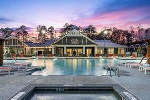 A hotel with a swimming pool, lounge chairs, and a covered area with a view of the surrounding trees. - Bright and Modern Retreat Near UGA & Five Points (Athens)