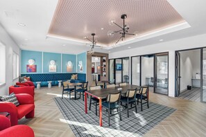 A modern interior with a dining area, seating, and a kitchen visible through glass doors. - Bright and Modern Retreat Near UGA & Five Points (Athens)
