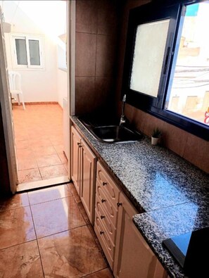 A kitchen with a granite countertop, a sink, and a window. - La Casa de las Palmeras (Central Lanzarote) (Arrecife)