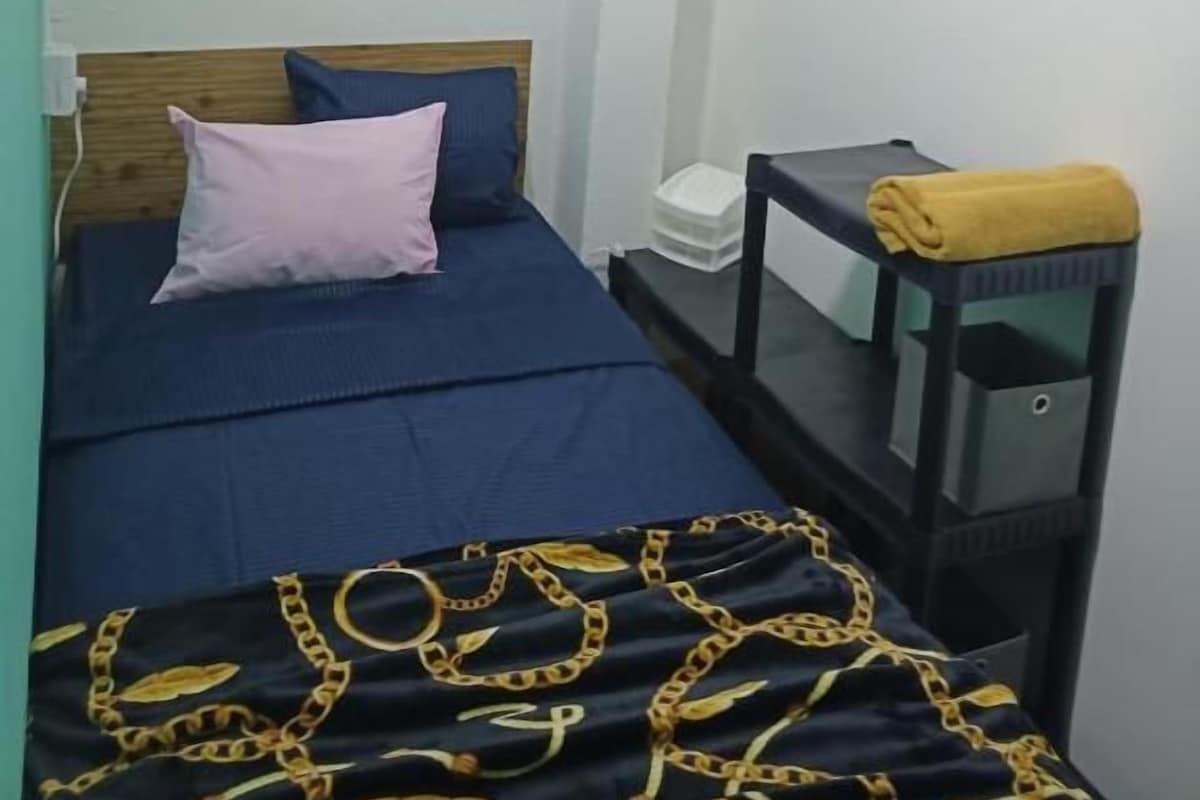 A bedroom with a bed, a bedside table, and wall decorations.