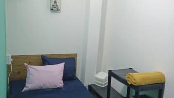 A bedroom with a bed, a bedside table, and wall decorations.