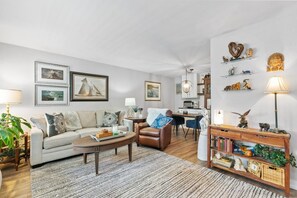 Ein Wohnzimmer mit einer Couch, einem Couchtisch und einem Holzkonsolentisch mit Dekoration.