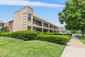 A multi-story building with a brick facade, a flat roof, and a series of windows. - Cozy 1-bedroom condo in delightful Oak Park with AC (Oak Park)