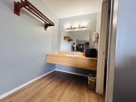 A bathroom with a wooden vanity, a towel rack, and a mirror.