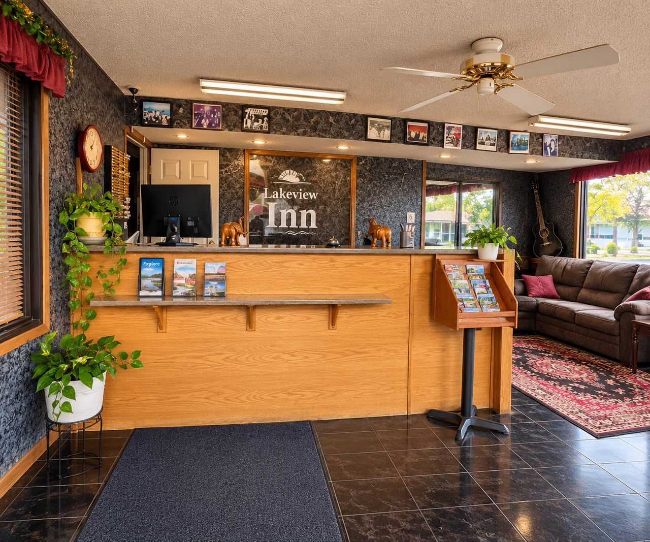 A reception area with a wooden counter, a clock, and framed pictures on the wall.