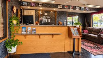 A reception area with a wooden counter, a clock, and framed pictures on the wall.