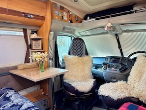 A cozy interior with a table, chairs, and a window.