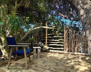 Una terraza de madera con un banco y una valla de madera.