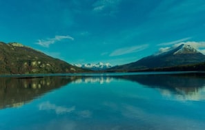 A tranquil lake with mountains in the background.