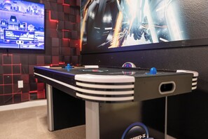 A foosball table with a digital display screen in the background. - 3BR Townhome | Themed Room + Pool | Gated (Kissimmee)