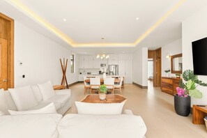 Uma sala de estar moderna com sofá, mesa de centro e área de refeições.