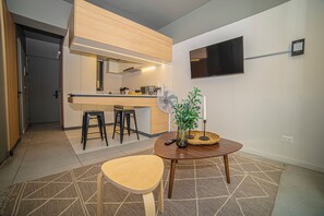 A modern kitchen with a wooden countertop, bar stools, a dining table with a vase, and a flat-screen TV mounted on the wall. - Study with a large window · Featured design (H07) (Providencia)