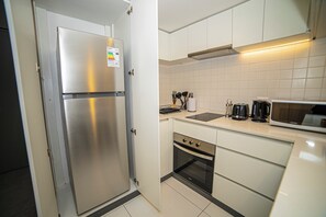 A modern kitchen with stainless steel appliances, including a refrigerator and oven, white cabinetry, and a microwave. - Study with a large window · Featured design (H07) (Providencia)