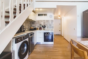 A modern kitchen with a built-in dishwasher, oven, and coffee maker. - Charming duplex with a view of the marina and the cistern (Le Gosier)