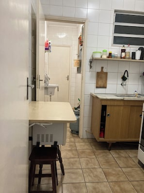 A kitchen with a wooden counter, a sink, and a window above the counter. - Apartment in Guarujá - Enseada Beach - Excellent (Guarujá)