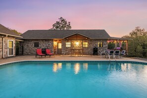 A stone house with a pool, outdoor seating, and a covered patio area. - Private Lakefront Retreat | Pool, Hot Tub, Kayaks (Hot Springs)