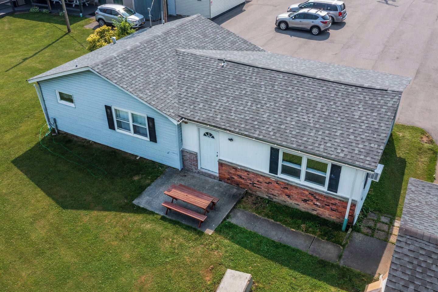 A single-story house with a front porch, a garage, and a small attached shed.