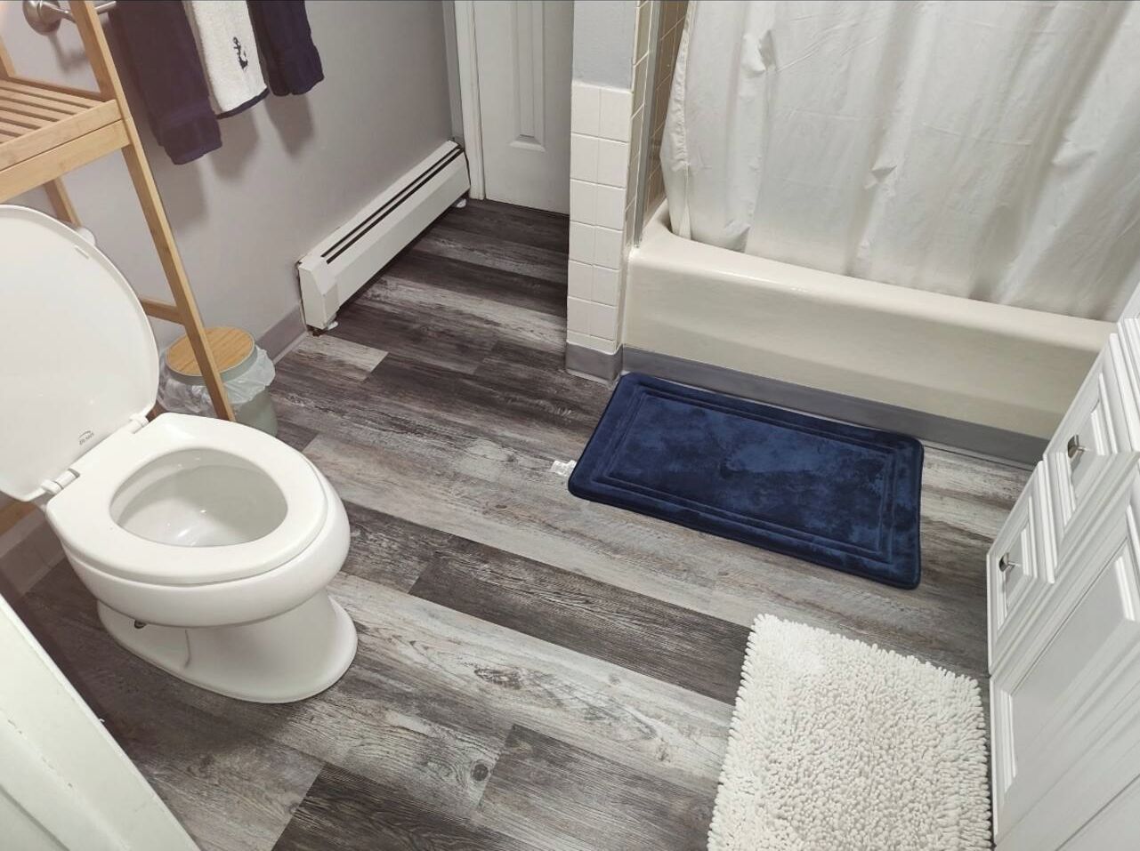 Clean full bath with tub/shower combo and modern wood-look floors
