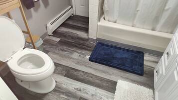 Clean full bath with tub/shower combo and modern wood-look floors