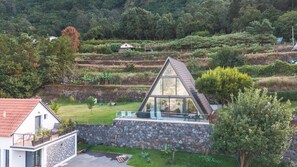 A modern house with a sloped roof, stone walls, and a glass balcony. - Star Lodge by Atlantic Holiday (São Vicente)