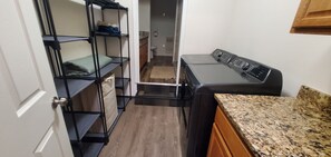 A compact kitchen with a built-in washer, wooden cabinets, and a small countertop. - North Pole Getaway + 2 bd Home w/ Double Garage (Fairbanks)