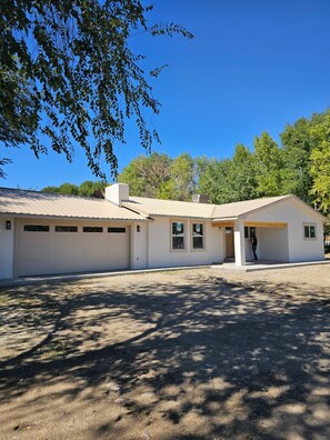 A single-story building with a garage, a covered porch, and a small attached structure. - 3-bedroom newly remodeled house in perfect Flora Vista (Flora Vista)
