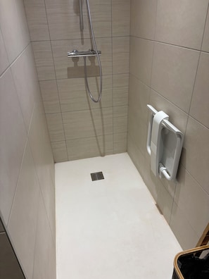 A small, tiled shower area with a handheld showerhead and a wall-mounted faucet. - Downtown ground-floor apartment (La Chapelle-en-Vercors)