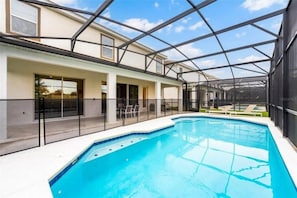 A swimming pool with a glass enclosure, lounge chairs, and a covered patio area. - 10 BD/ 8 BA/ Sonoma Resort - 2613 CA (Kissimmee)