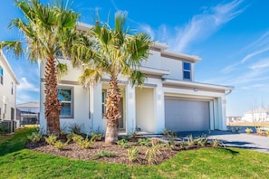 A modern two-story house with a garage, surrounded by a well-maintained lawn and palm trees. - 8 BD/ 5 BA/ Sonoma Resort - 2614 CA (Kissimmee)
