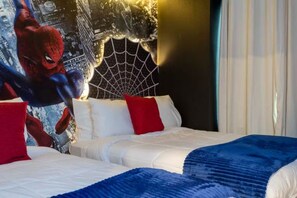 Une chambre d’hôtel avec un lit, des oreillers et une fresque murale représentant un super-héros.