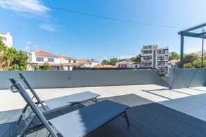 Eine Dachterrasse mit Außenmöbeln und Blick auf Wohnhäuser.