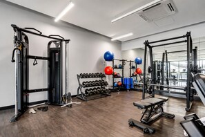 Een sportschool met gewichthefapparatuur, dumbbells en trainingsballen.