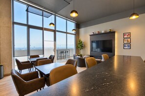 A modern conference room with a long table, chairs, a large TV screen, and a city view through large windows. - ¡A Pasos de Fundidora! Gym, Pool, Parking 2B2b 8H (Monterrey)