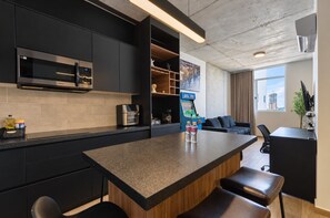 Cozinha moderna com ilha central, eletrodomésticos embutidos e área de estar com vista.
